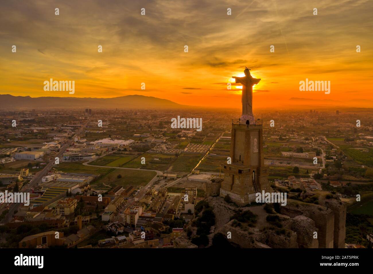 Monteagudo medieval castle ruin twelve rectangular towers circling the hilltop and the sacred heart of Jesus Christ statue on top near Murcia Spain Stock Photo