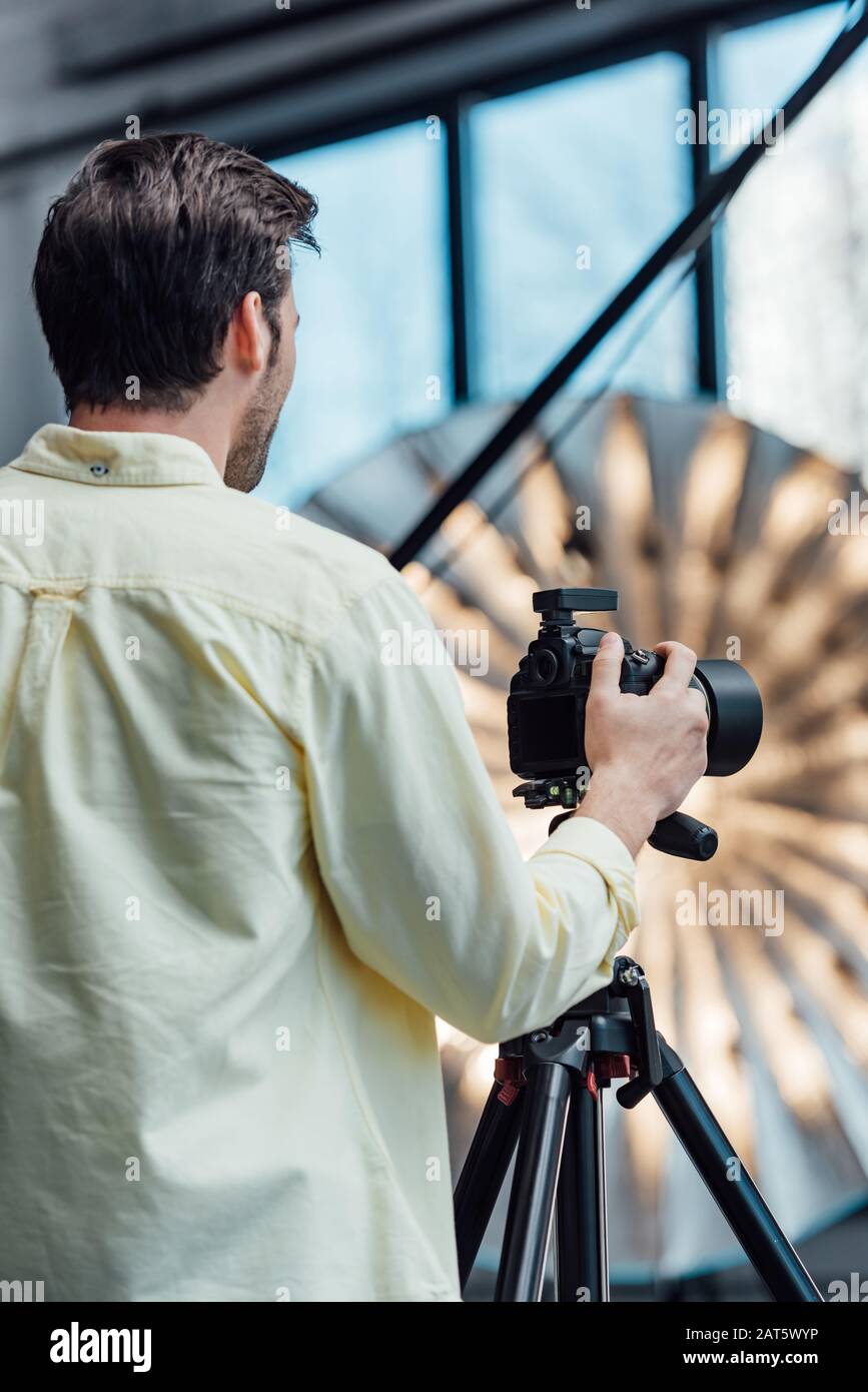 Photographer Back back view of photographer touching digital camera on tripod Stock Photo ...