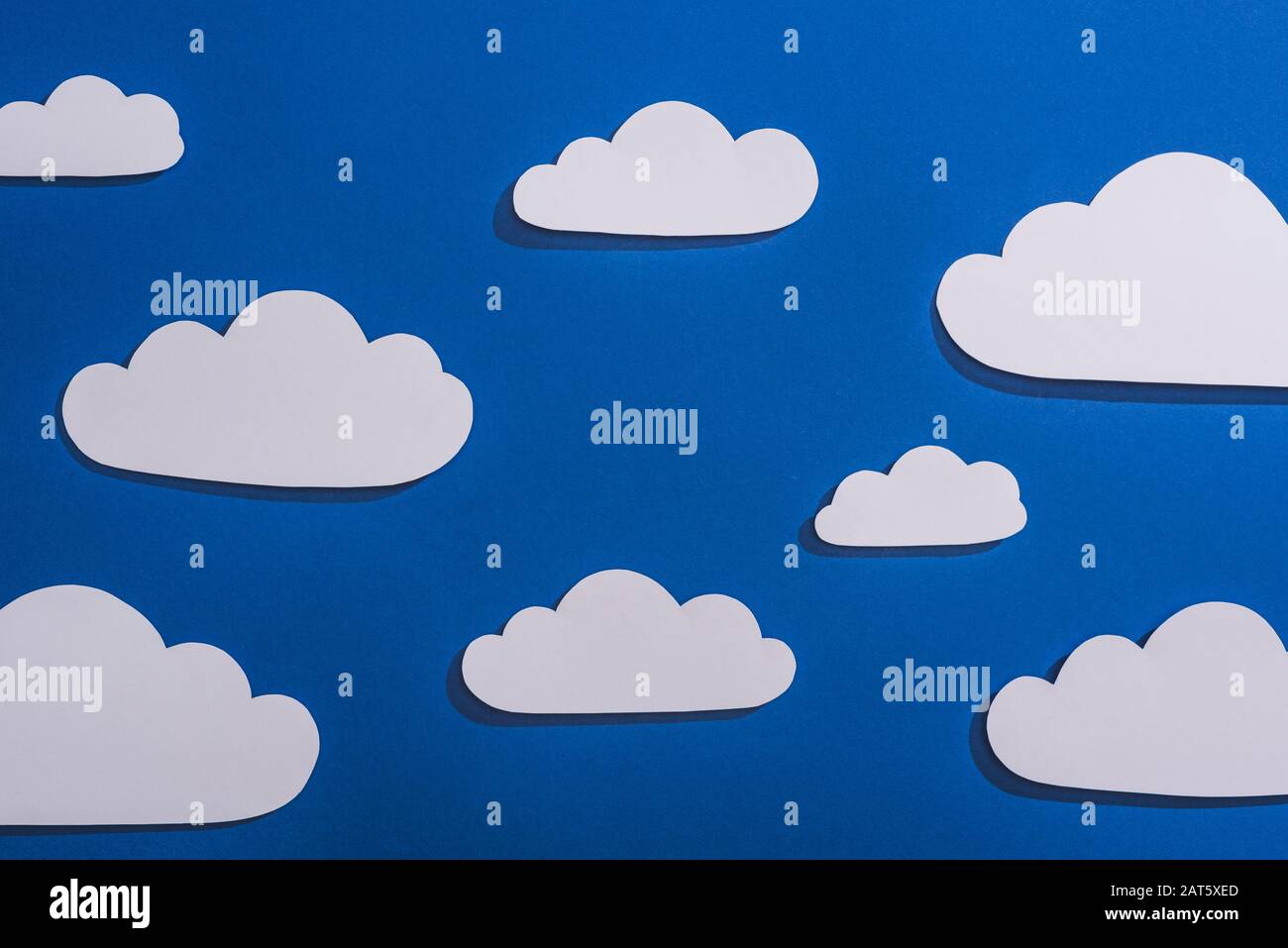 top view of white paper cut clouds on blue background Stock Photo - Alamy