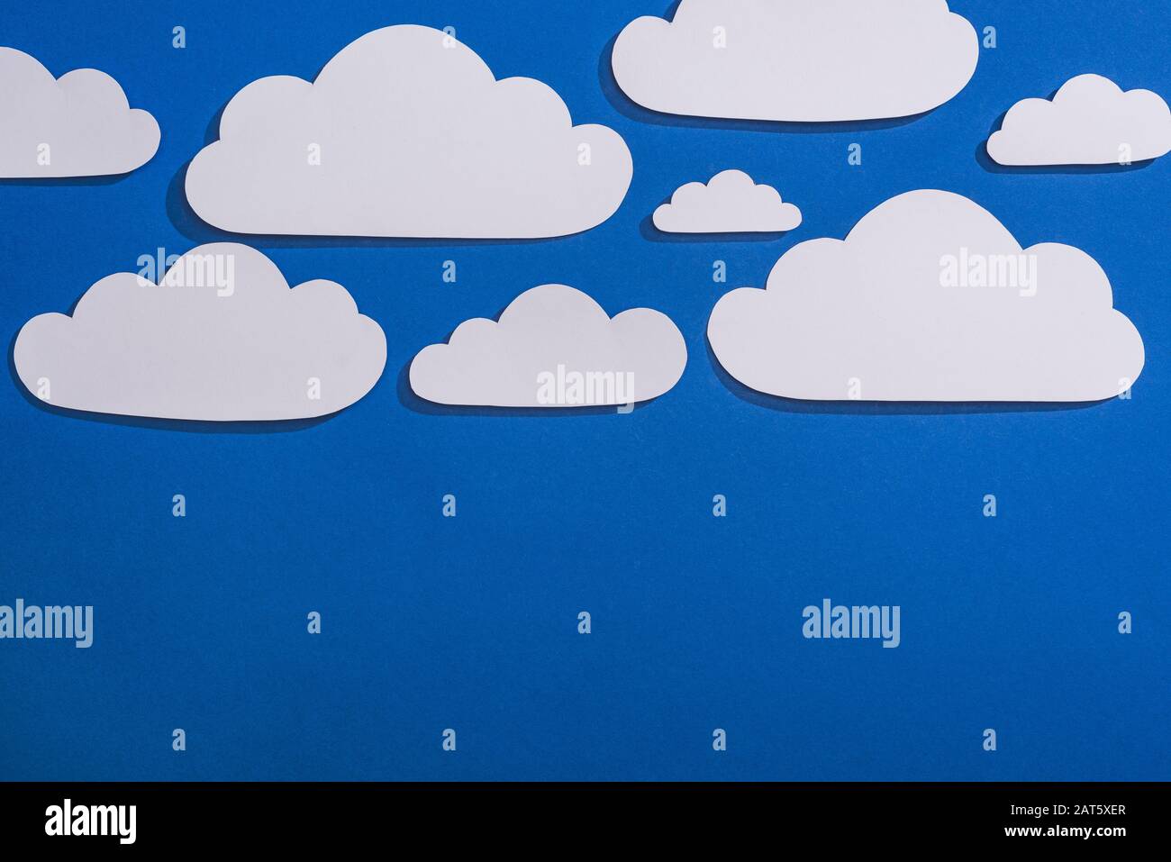 top view of white paper cut clouds on blue background Stock Photo - Alamy