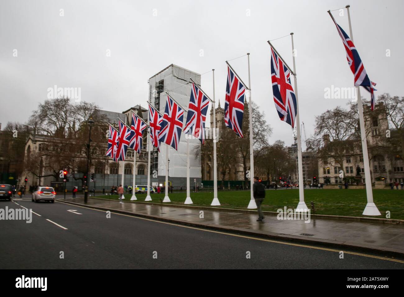 Union Jack flags hang at Parliament Square outside Houses of Parliament on the eve of Brexit Day.Pro-remain supporters with EU flags protest outside Houses of Parliament on the eve of Brexit Day. Britain will officially leave the European Union at 11pm (GMT) on 31 January 2020 and will cease to be a state member. Under the terms of the Withdrawal Agreement, UK will enter a transitional period and will abide by EU rules despite not being a member. Stock Photo