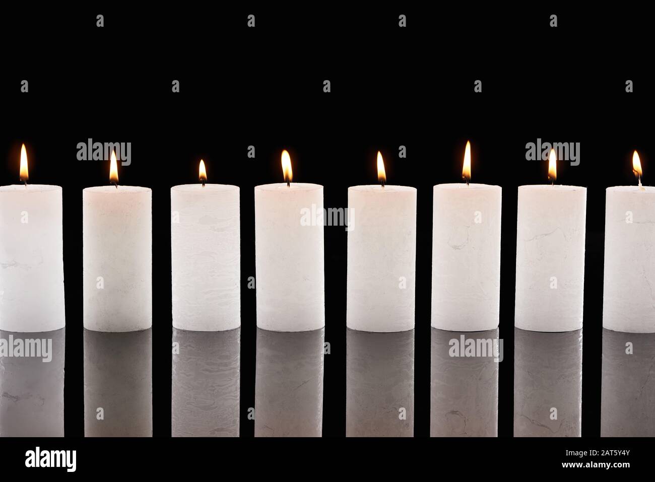 burning white candles glowing in line isolated on black Stock Photo Alamy