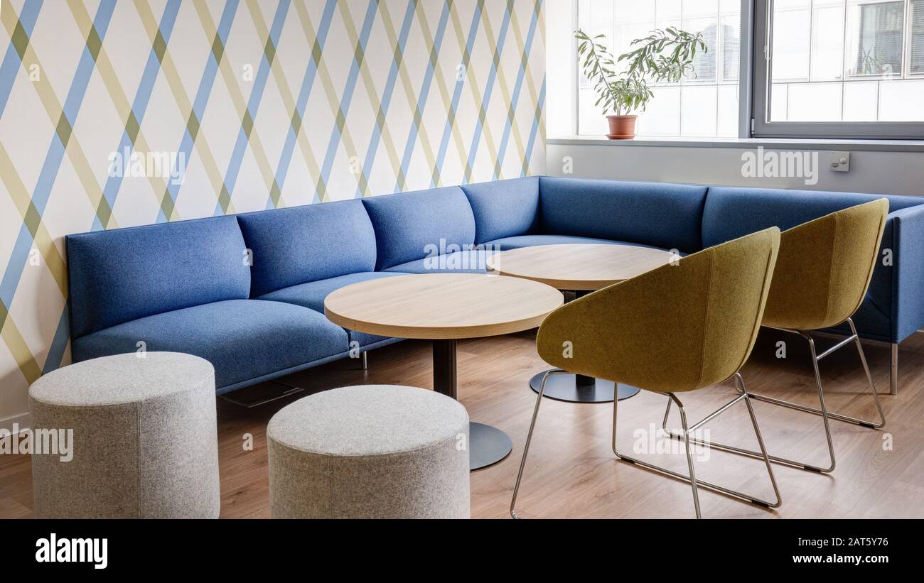 modern interior with blue sofas and round tables in the business center