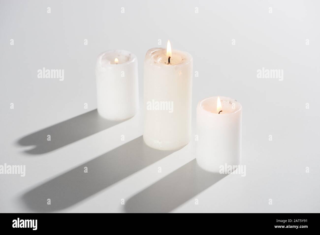 burning candles glowing on white background with shadow Stock Photo Alamy