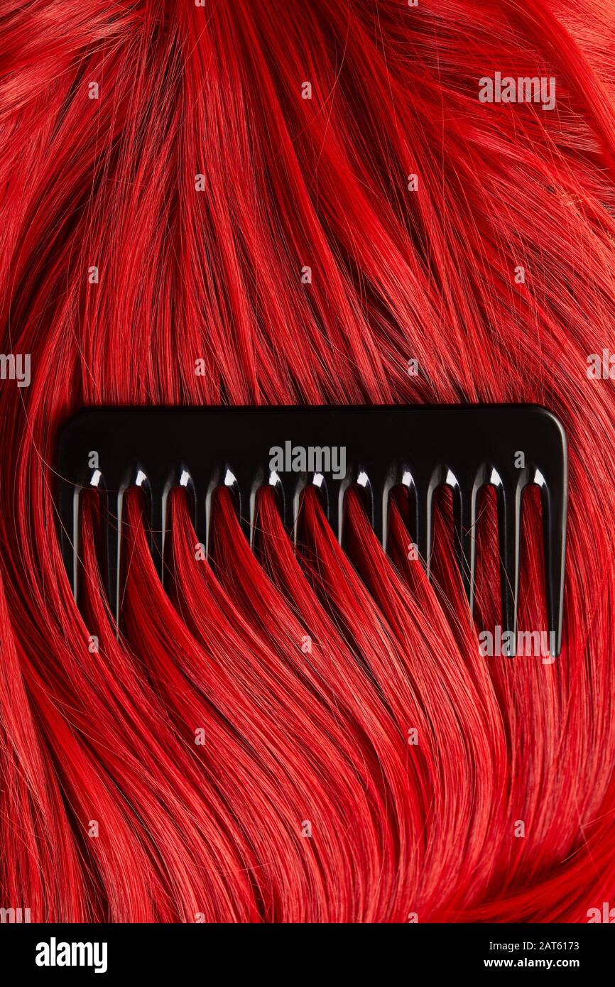 Top view of comb on colored red hair Stock Photo