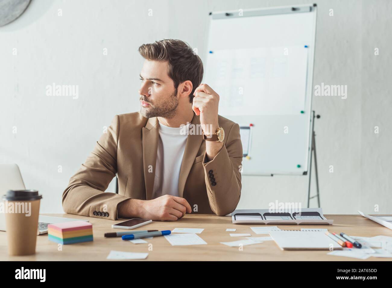 Creative designer looking away at table with mobile application layouts on table Stock Photo