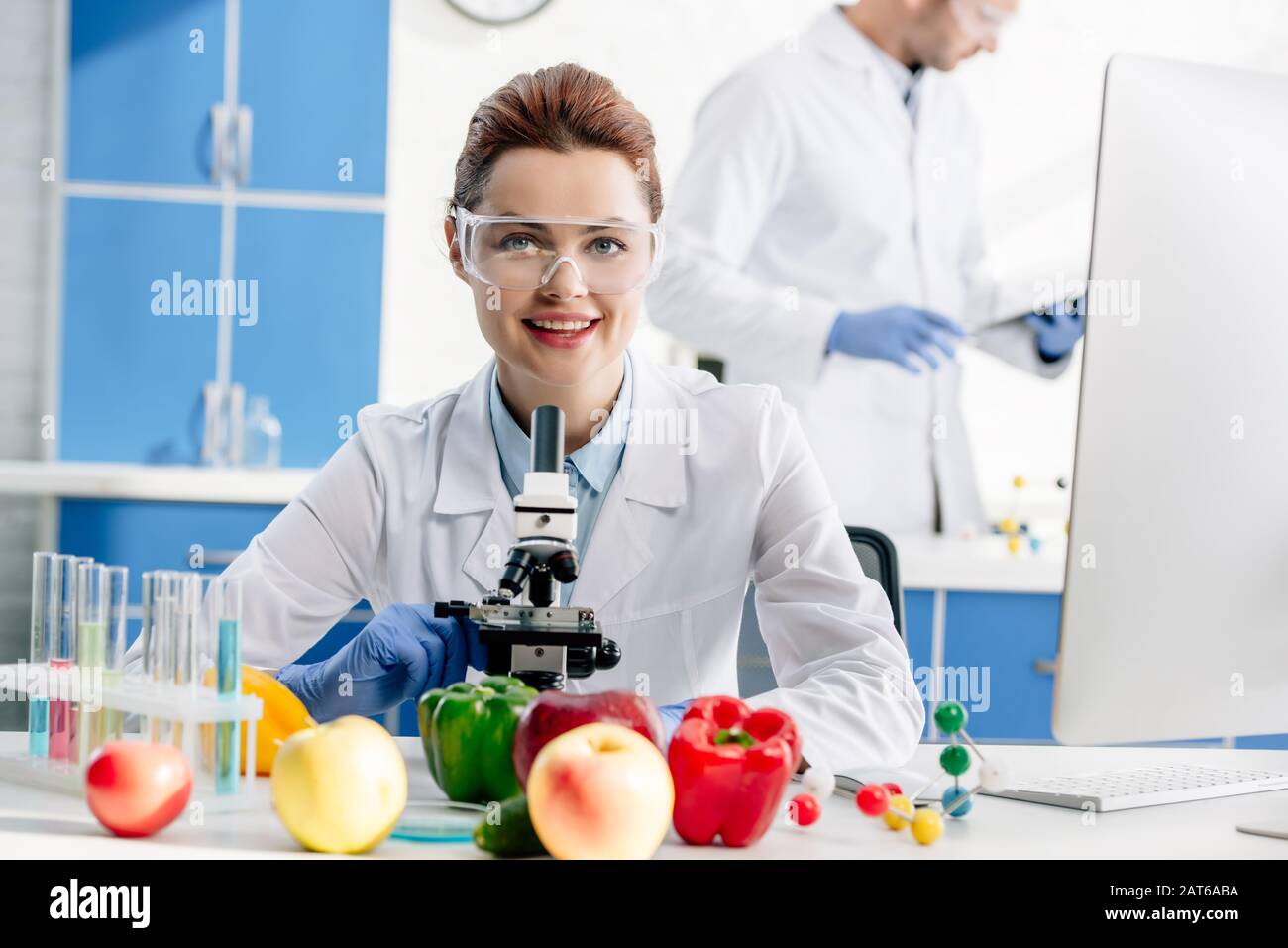 selective focus of smiling molecular nutritionist looking at camera Stock Photo