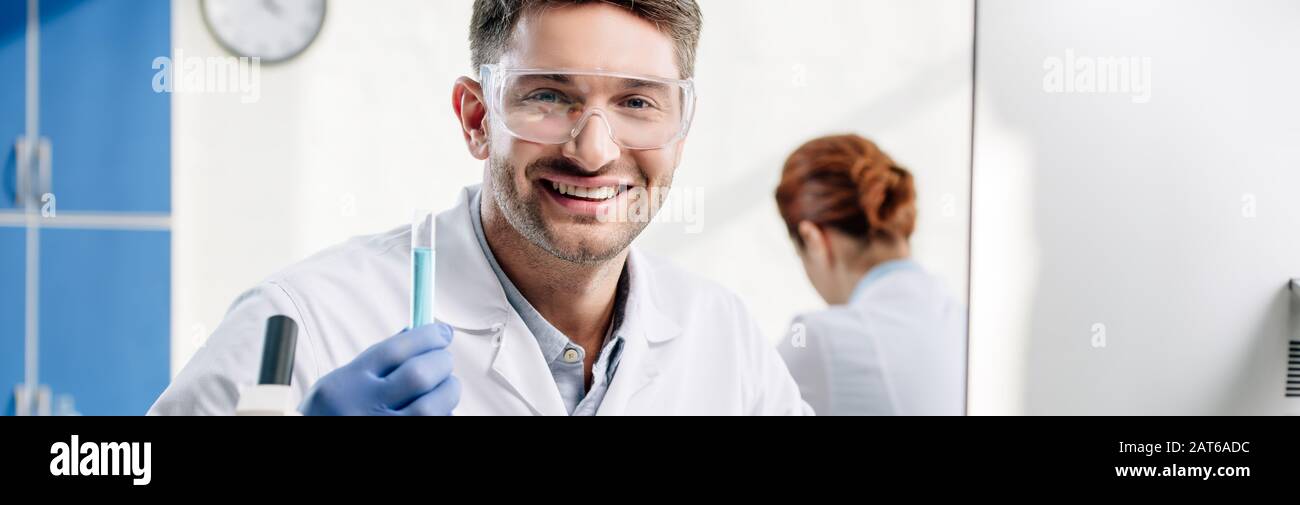 panoramic shot of smiling molecular nutritionist holding test tube Stock Photo