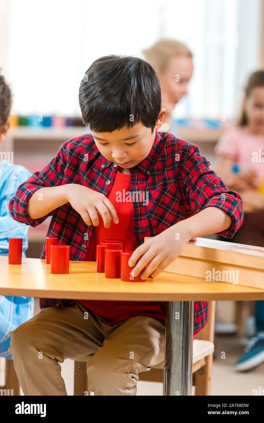 Selective focus of asian kid folding educational game with teacher and ...