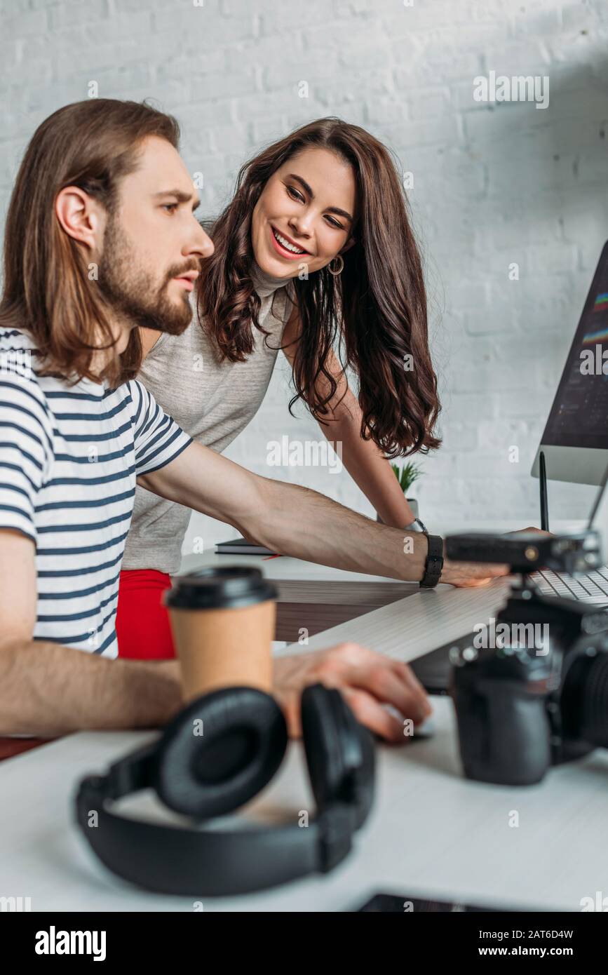 selective focus of happy art editor looking at coworker Stock Photo Alamy