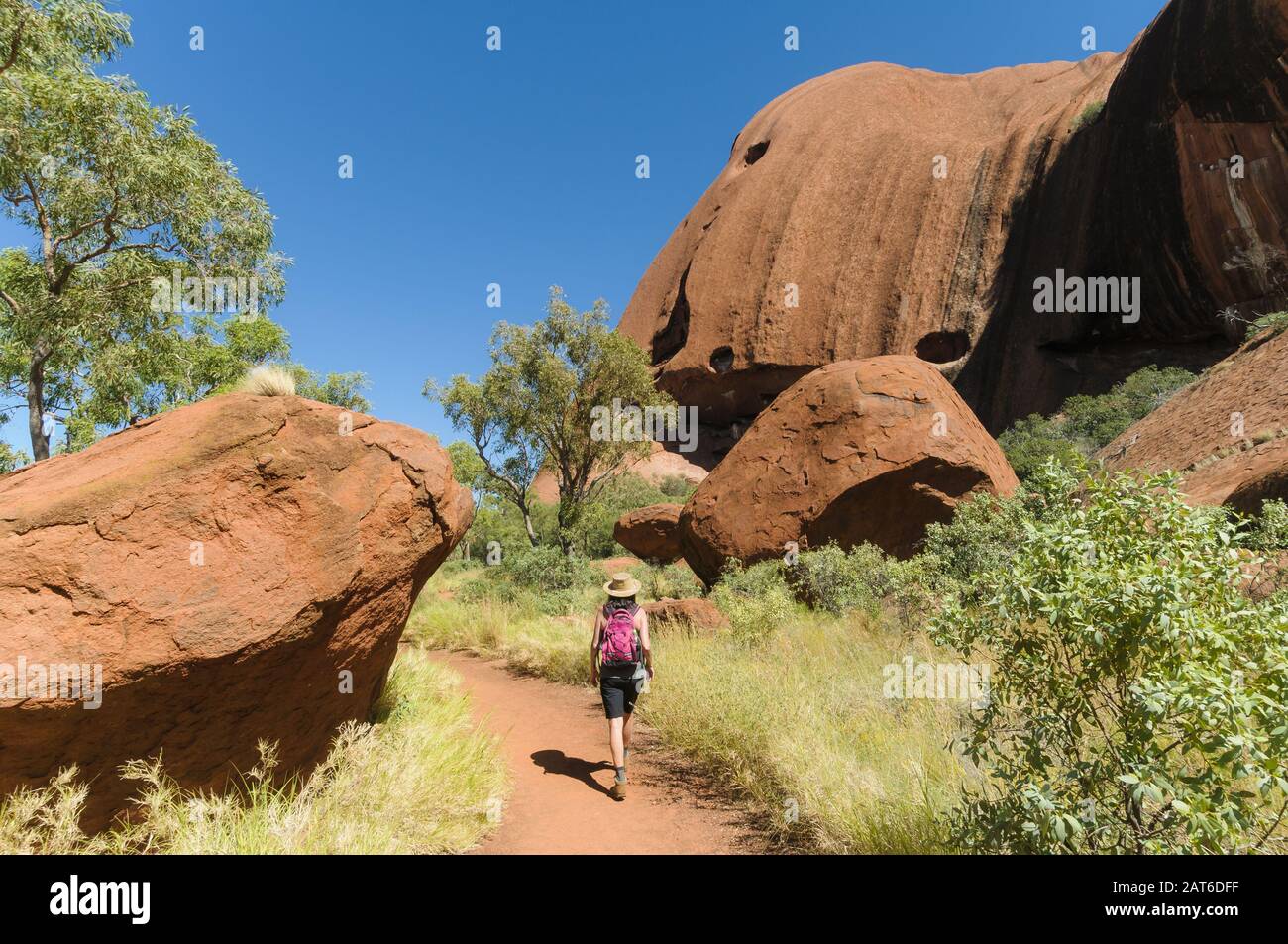 Bushwalker follows the track around Uluru(Ayres Rock) in Central Australia. Stock Photo