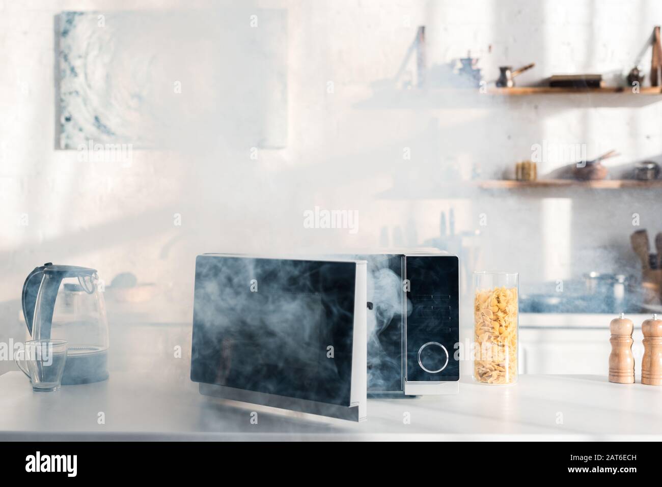 electric kettle, pasta, broken and steamy microwave on table in kitchen