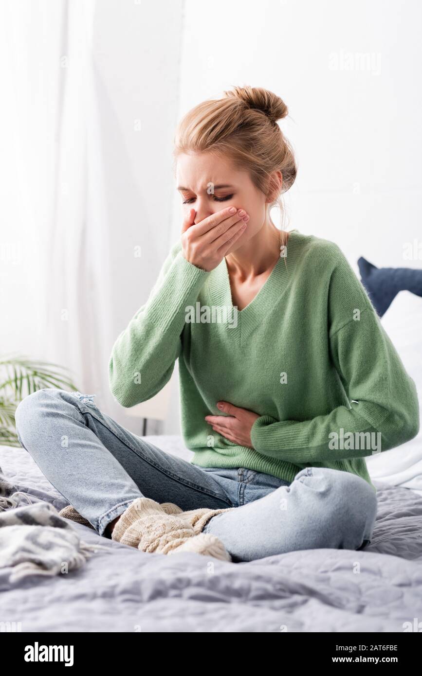 beautiful woman having nausea and sitting on bed Stock Photo Alamy