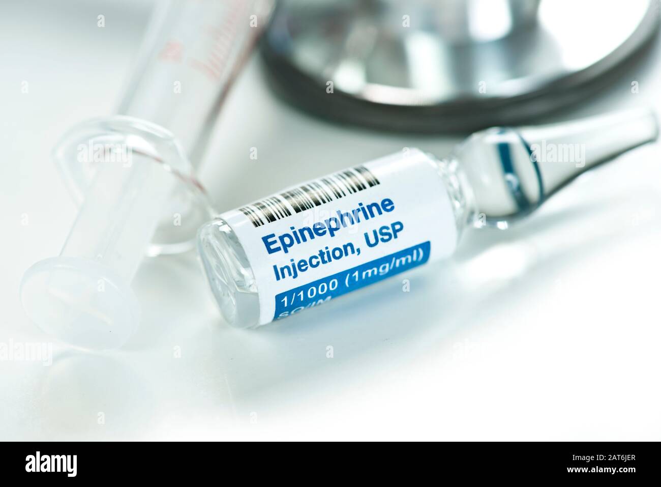 Close up of epinephrine injection solution in clear1 ml ampule with syringe and stethoscope. Stock Photo