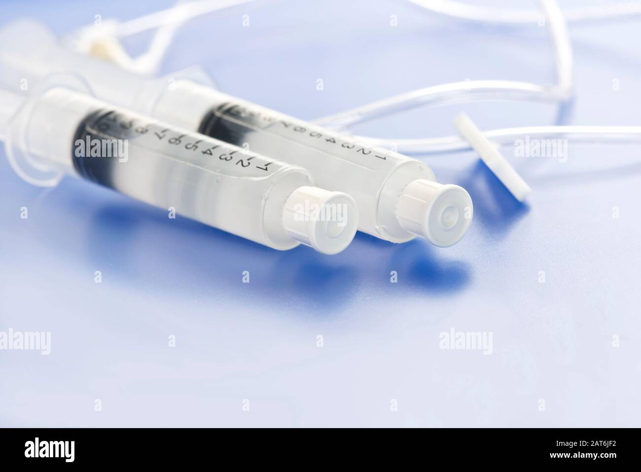Sterile saline flush injection vials with IV tubing on blue tray. Stock Photo