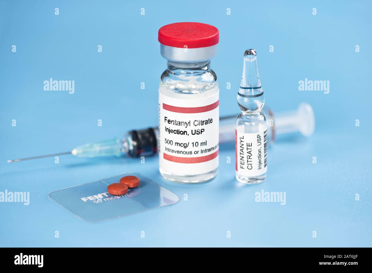 Fentanyl citrate injection ampule, vial, clear fentanyl dermal patch, tablets and syringe on blue tray. Stock Photo