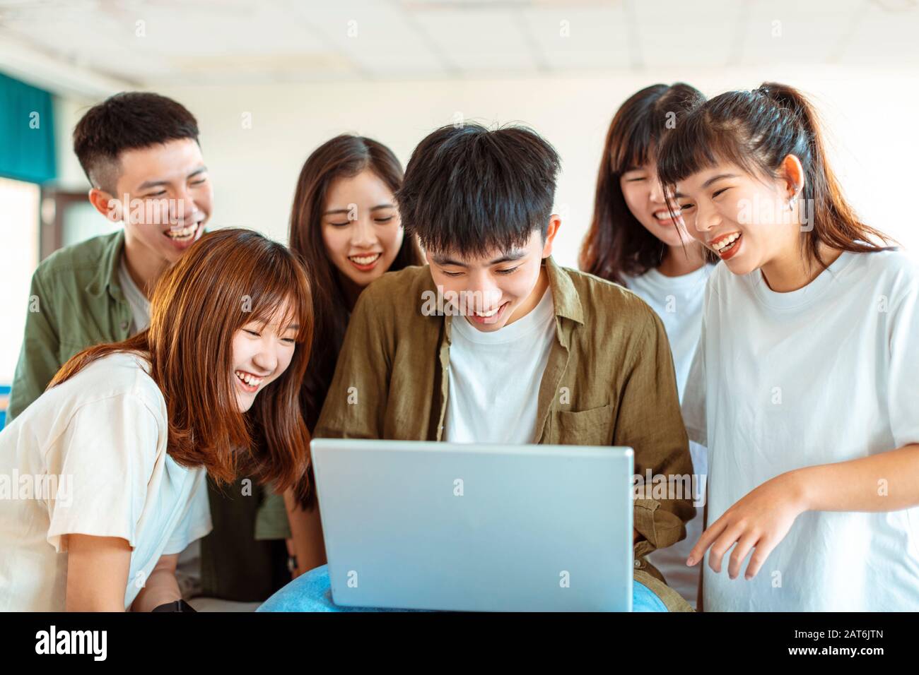 excited college students looking at laptop  in classroom Stock Photo
