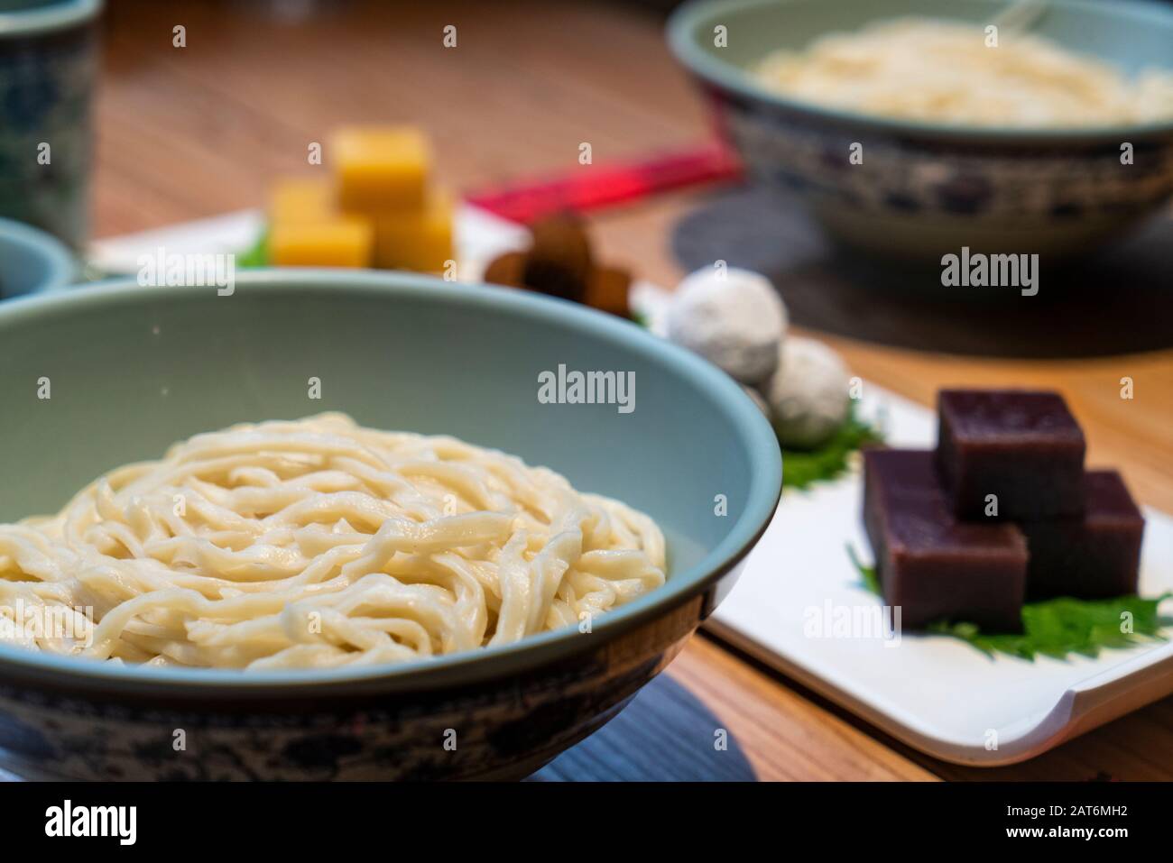 Chinese noodles with Beijing traditional pastry, such as yellow Pea jelly, Rolling donkey (glutinous rice rolls with sweet bean flour) on the table Stock Photo