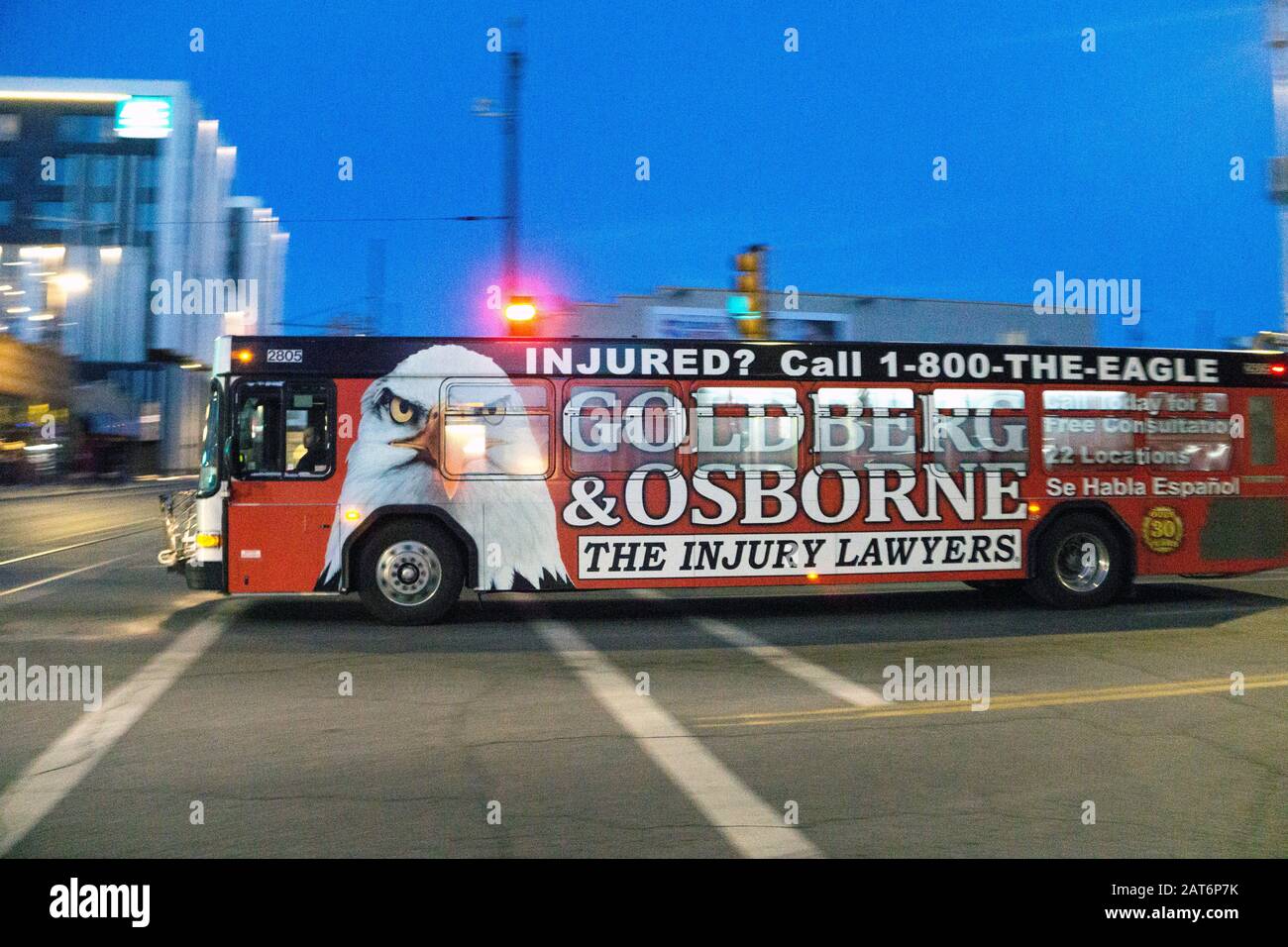 Tucson Sun Tran bus in motion with both sides painted over including doors & windows except driver's with giant advertising for firm of injury lawyers Stock Photo