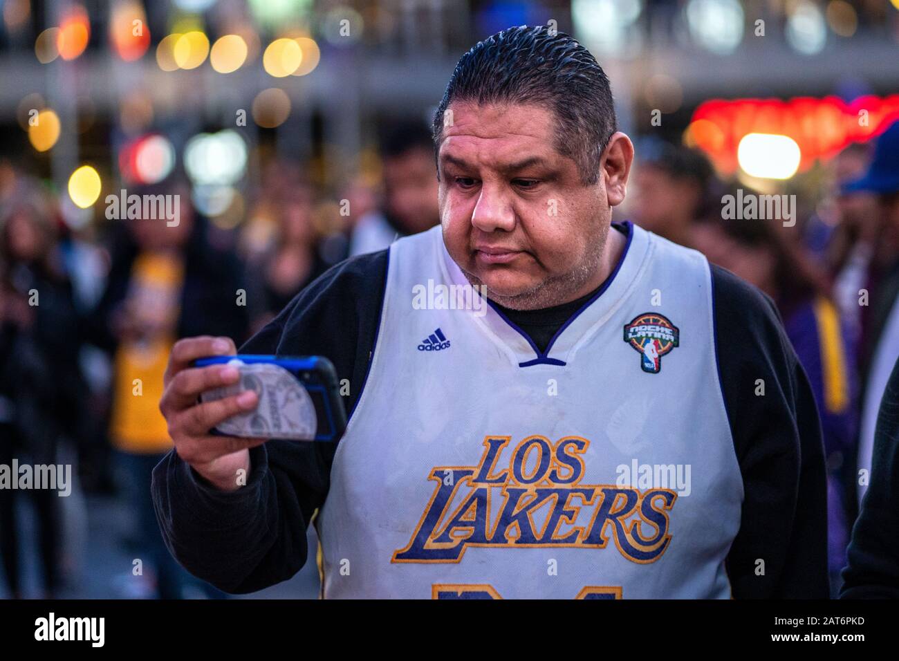 Los Angeles, United States. 29th Jan, 2020. A fan takes pictures of a makeshift memorial in honour of the former NBA star Kobe Bryant outside the Staples Center in Los Angeles.Kobe and his daughter Gianna were among the nine people who died in a helicopter crash. Credit: SOPA Images Limited/Alamy Live News Stock Photo