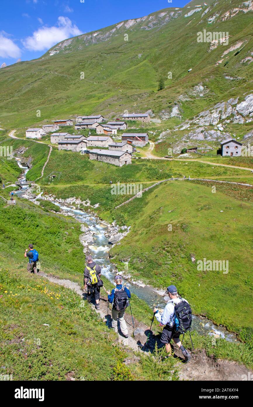 Hikers approaching Jagdhausalm village in Hohe Tauern National Park Stock Photo