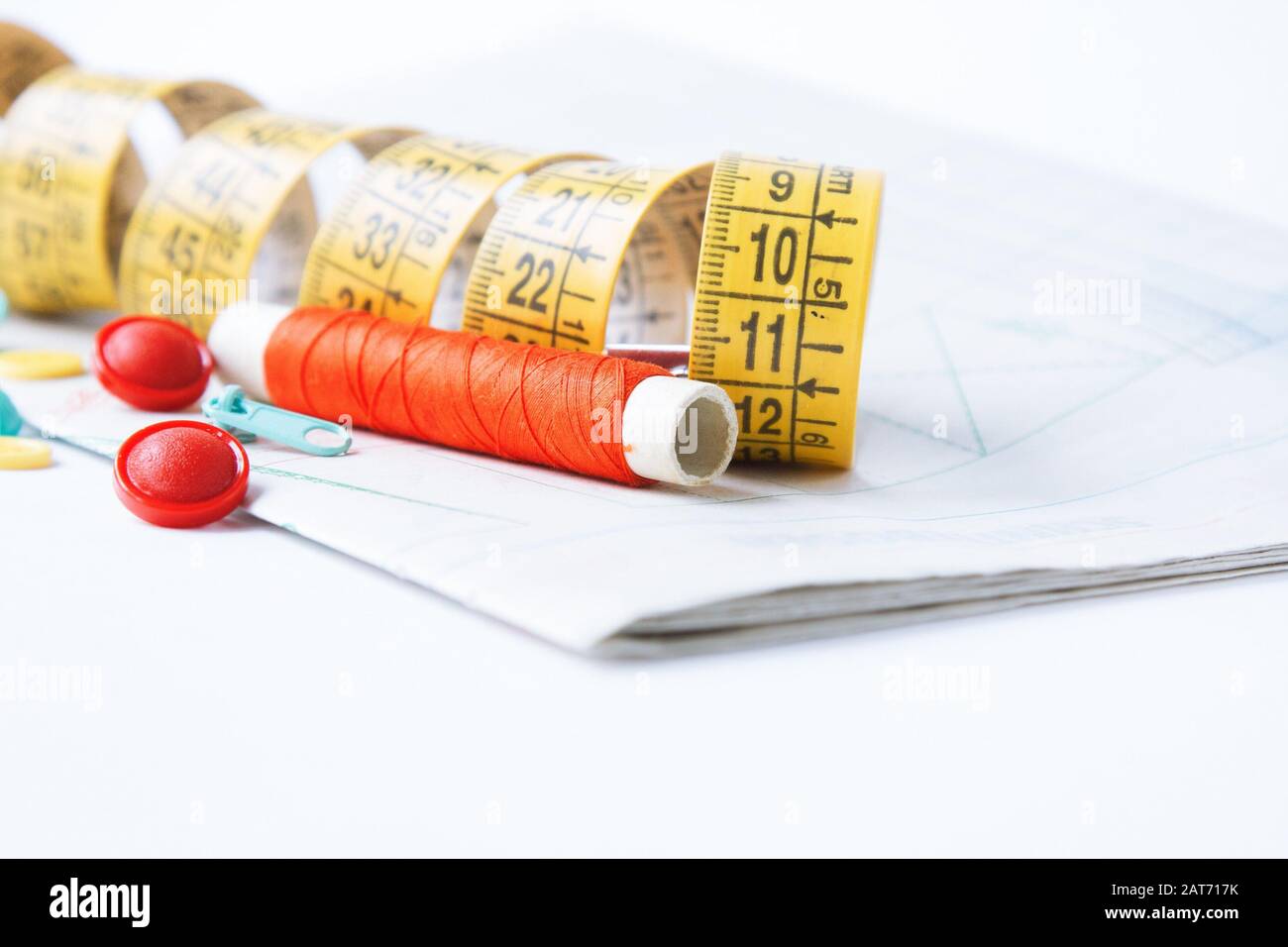 Sewing supplies on white sewing thread, pattern, centimeter, buttons Stock Photo