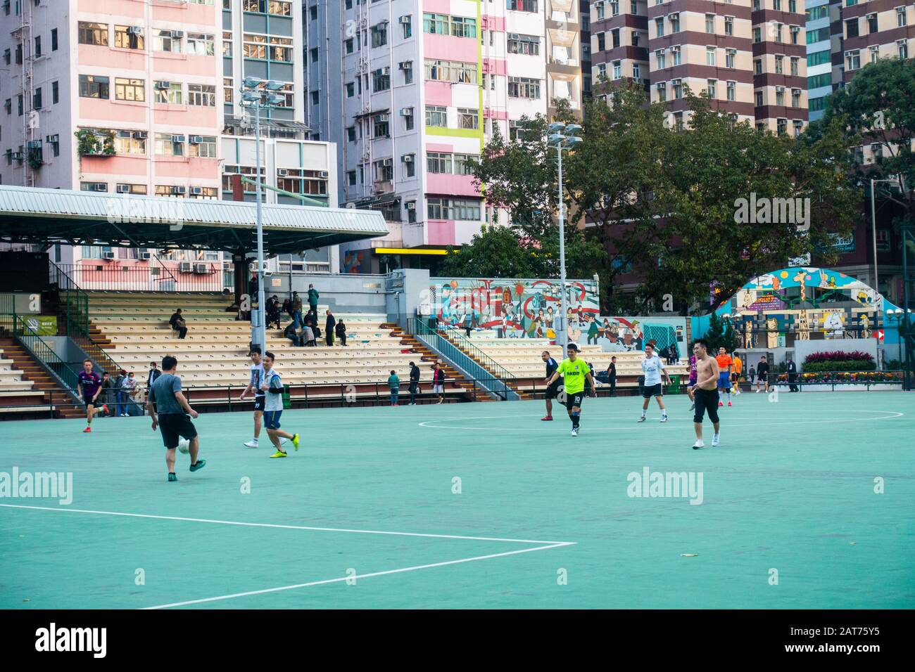 Hong Kong - February 2020: People doing exercise playing football at public playground in Wan Chai Stock Photo