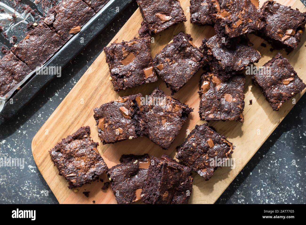 Chocolate brownie squares taken out of baking tin and place on wooden