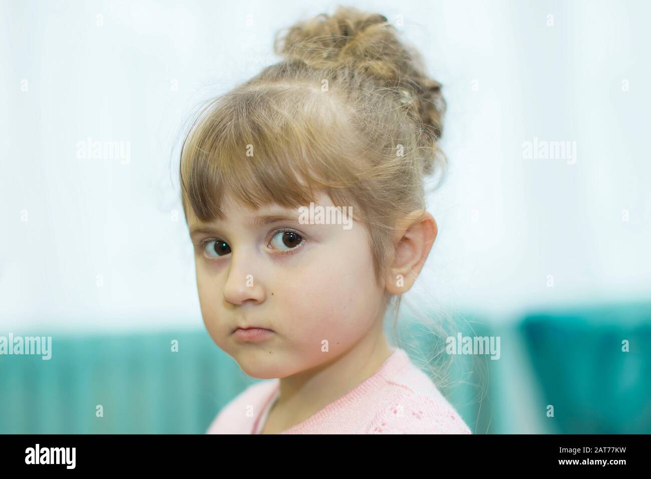 Morning party in kindergarten.The face of a serious three year old girl. Stock Photo