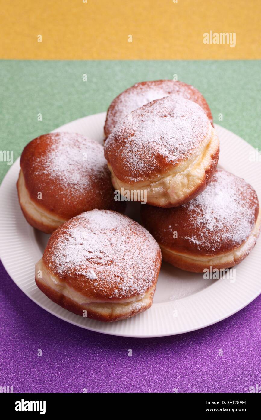 Sweet fat donuts on Mardi Gras purple, green, and yellow background Stock Photo