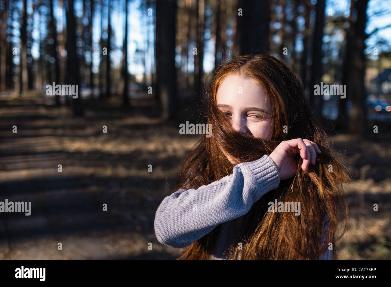 Little cute girl with long red hair posing in a pine park Stock Photo ...