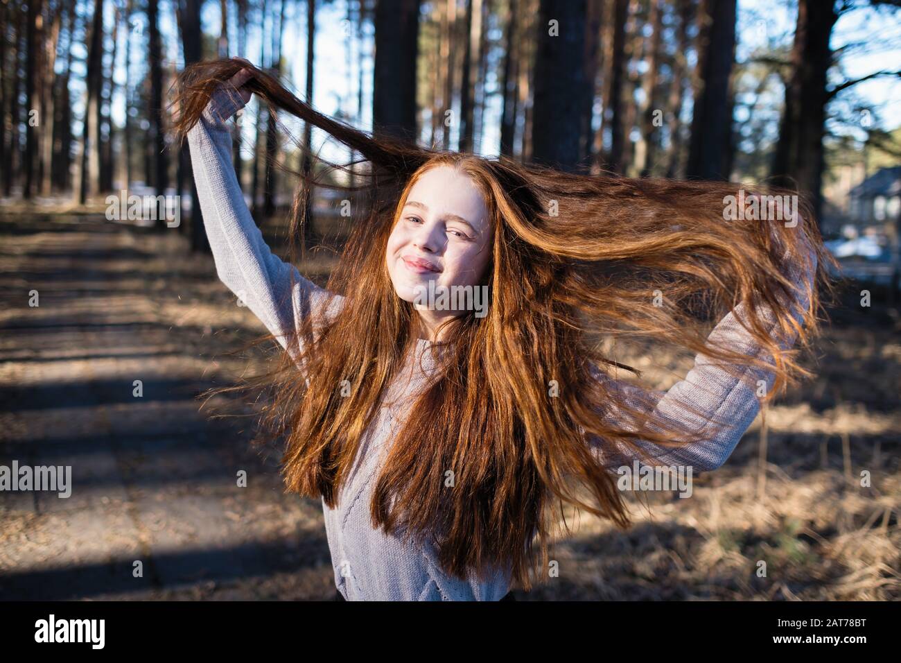 Cute girl with long red hair posing for camera in a pine park Stock ...