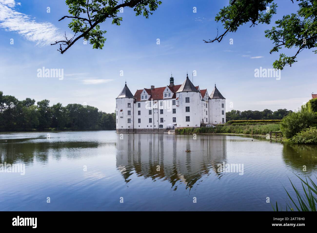 Historic castle with reflection in the lake in Glucksburg, Germany Stock Photo