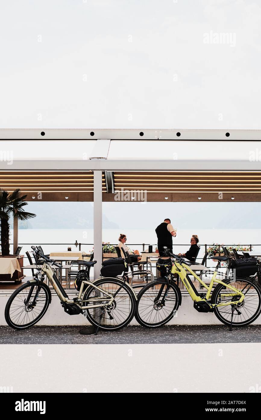 A holiday couple taking a lunch break from their summer cycling holiday - parked bicycles - electric bicycle - electric bikes - retirement lifestyle Stock Photo