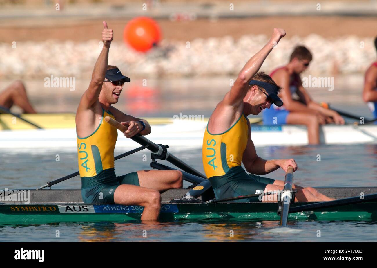 20040821 Olympic Games Athens Greece [Rowing-Sat Finals day] Schinias. AUS  M2- left Drew Ginn and James Tompkins raise their arms after crossing the  line to claim the Olympic gold medal in the