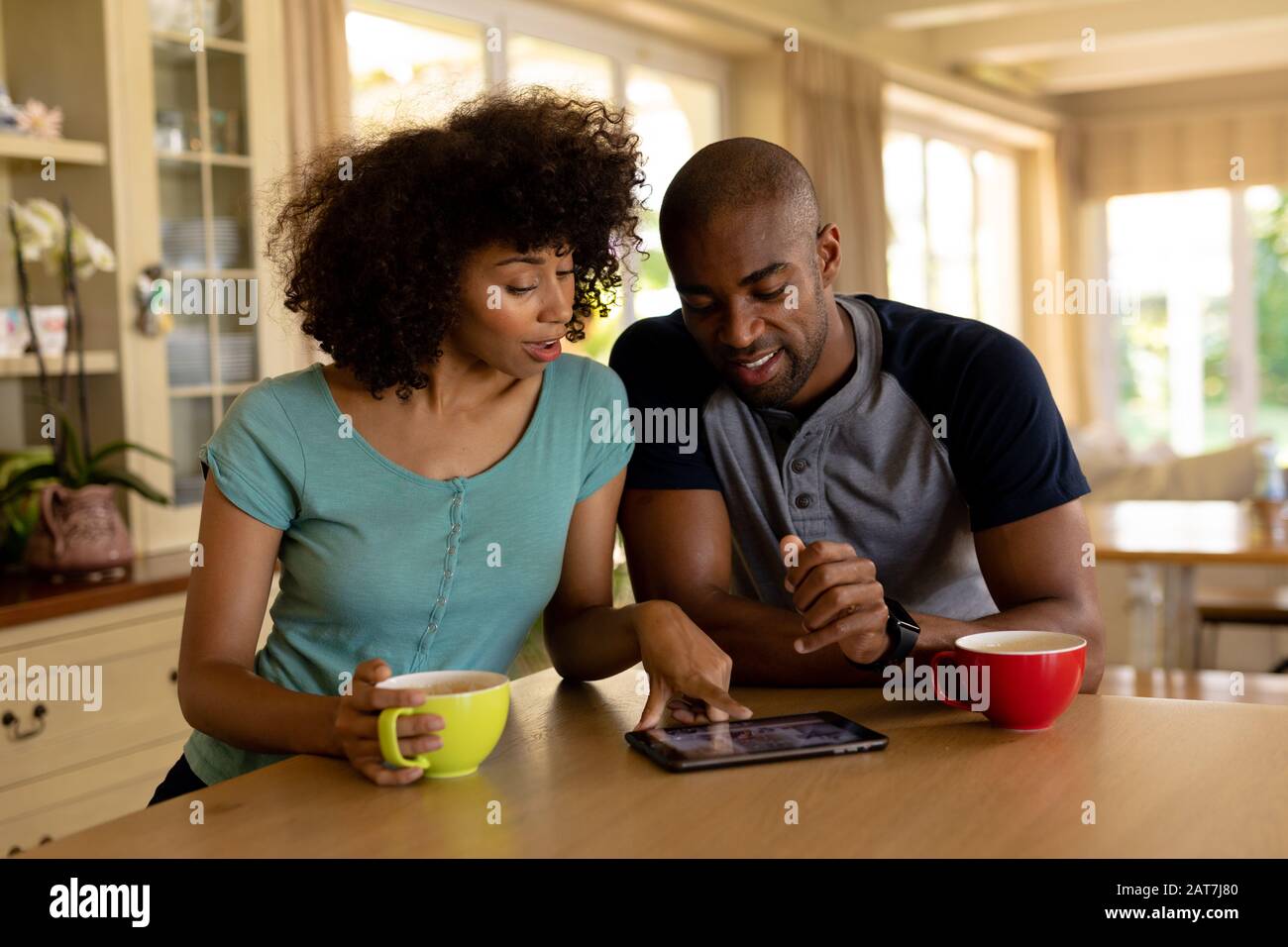 Happy young couple using tablet computer in the kitchen Stock Photo