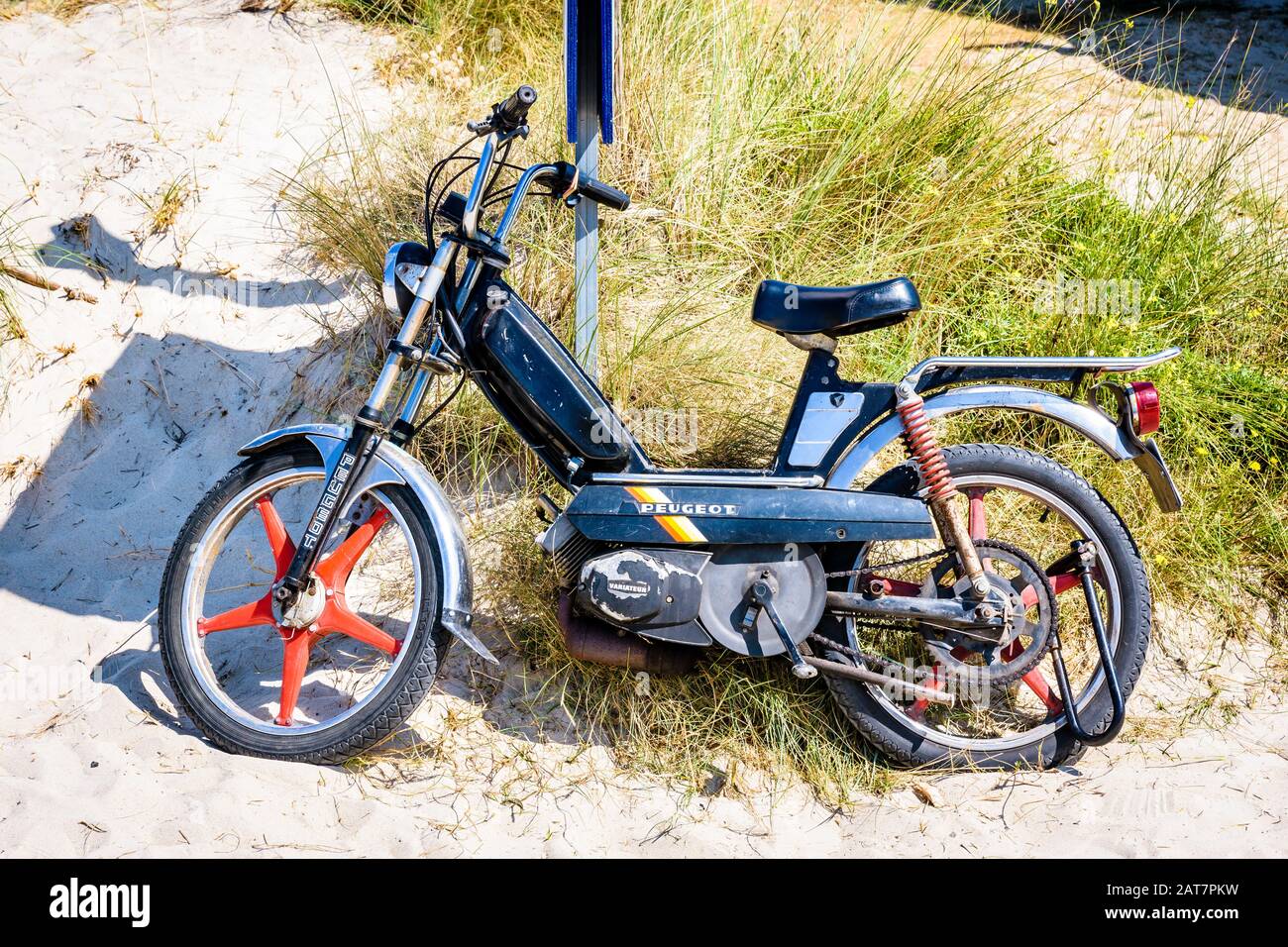 A vintage Peugeot 103 SP black moped from the early 1980s with red Rigida  Leleu 5-spoke wheels leaning against a pole in the sun at the beach Stock  Photo - Alamy