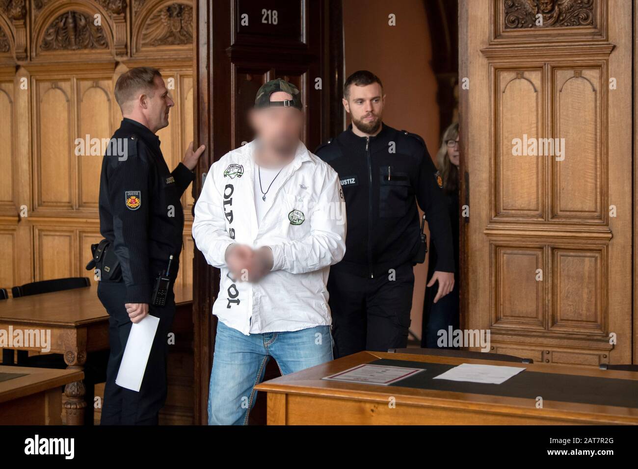 Bremen, Germany. 31st Jan, 2020. A defendant on trial for murder is led into the courtroom. The two defendants were convicted of murder with a kitchen knife and a steak knife. The victim died from the injuries. Credit: Sina Schuldt/dpa - ATTENTION: Person(s) has (have) been pixelated for legal reasons/dpa/Alamy Live News Stock Photo