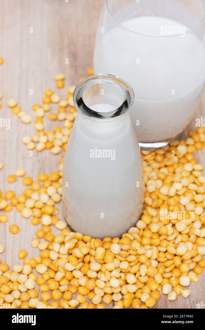 Vegan plant based milk alternatives. Vegan milk alternatives. Pea milk with yellow split peas on a wooden board Stock Photo