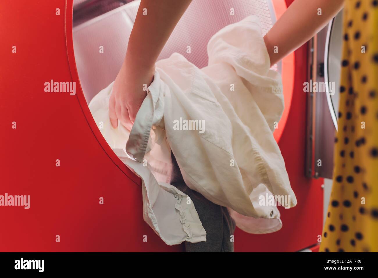 Hands to load the Laundry in the washing machine at the dry cleaners