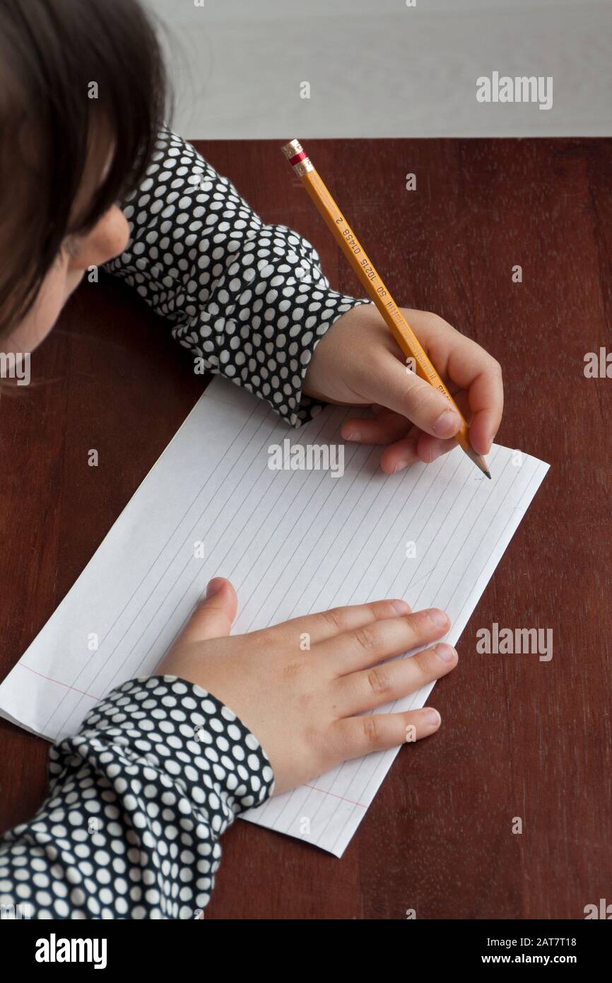 Young girl using left hand to write Stock Photo Alamy