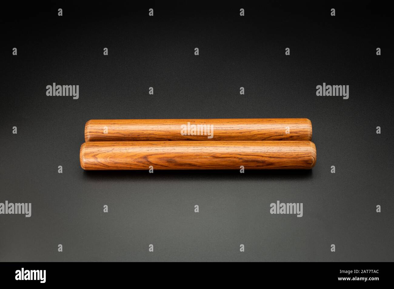 Closeup of a pair of wooden claves lying on a black underground Stock Photo