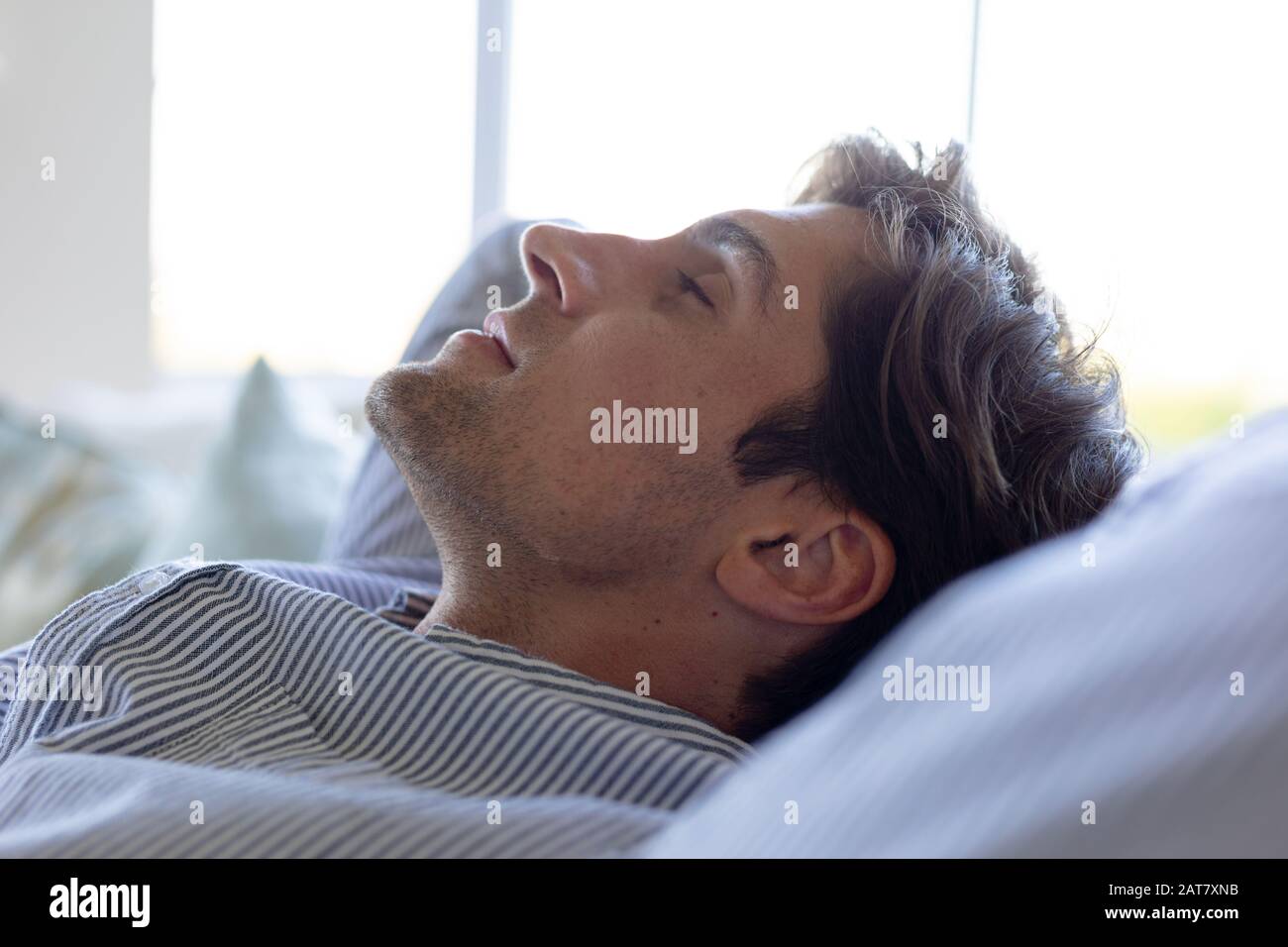 Young man relaxing on sofa at home Stock Photo