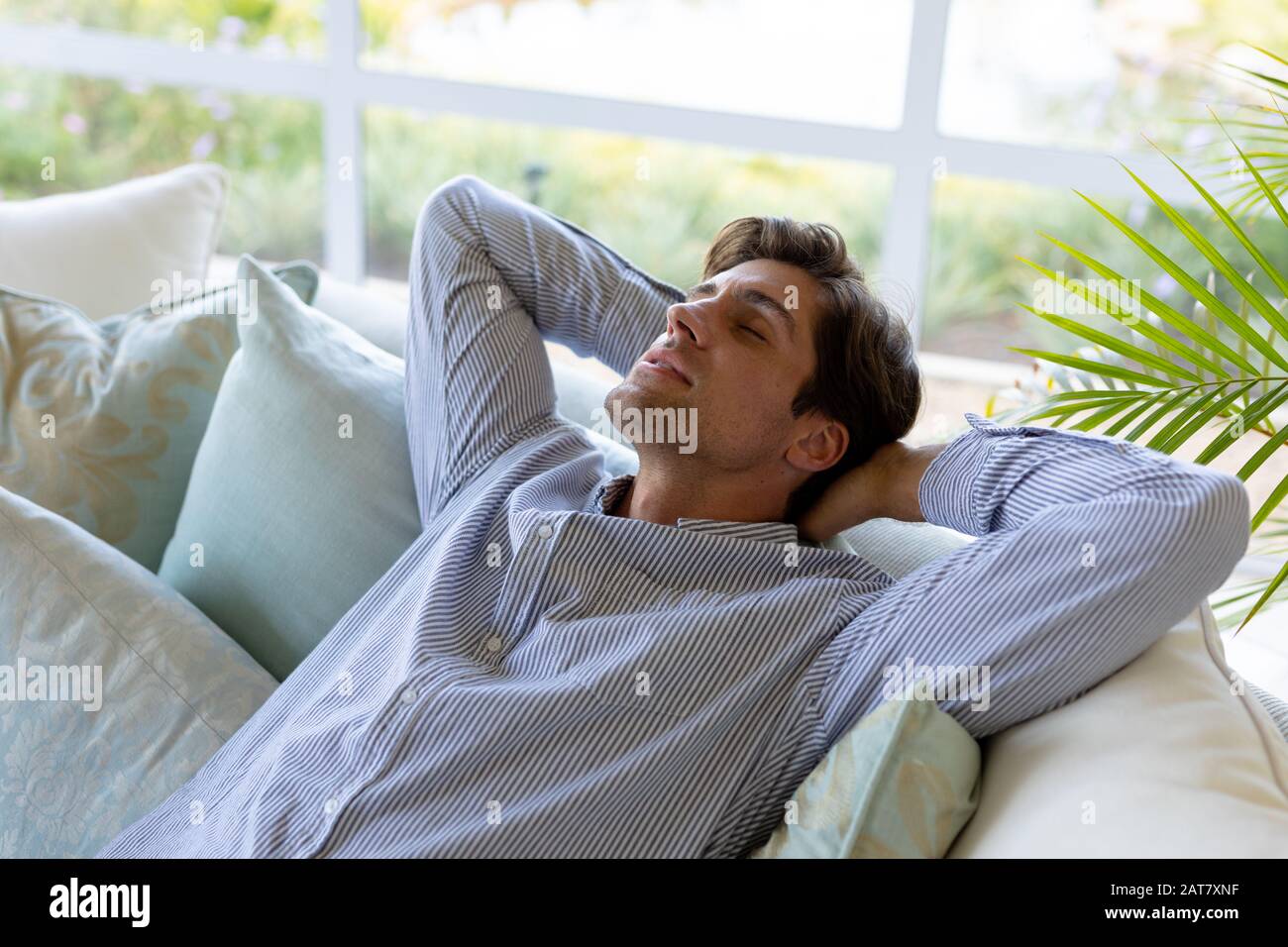 Young man relaxing on sofa at home Stock Photo