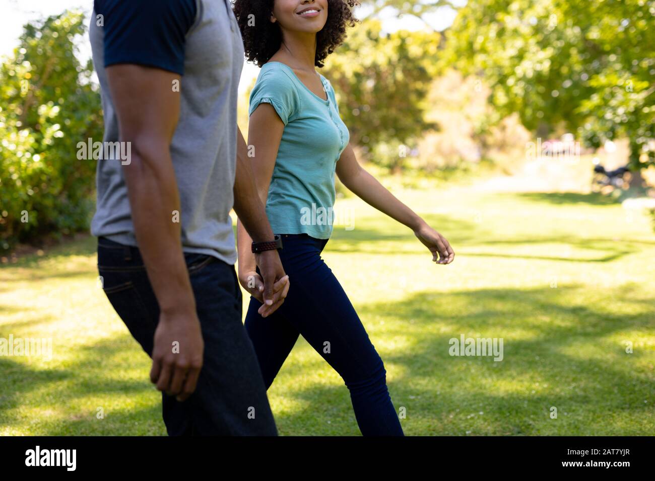 Happy young couple walking hand in hand in the garden Stock Photo - Alamy