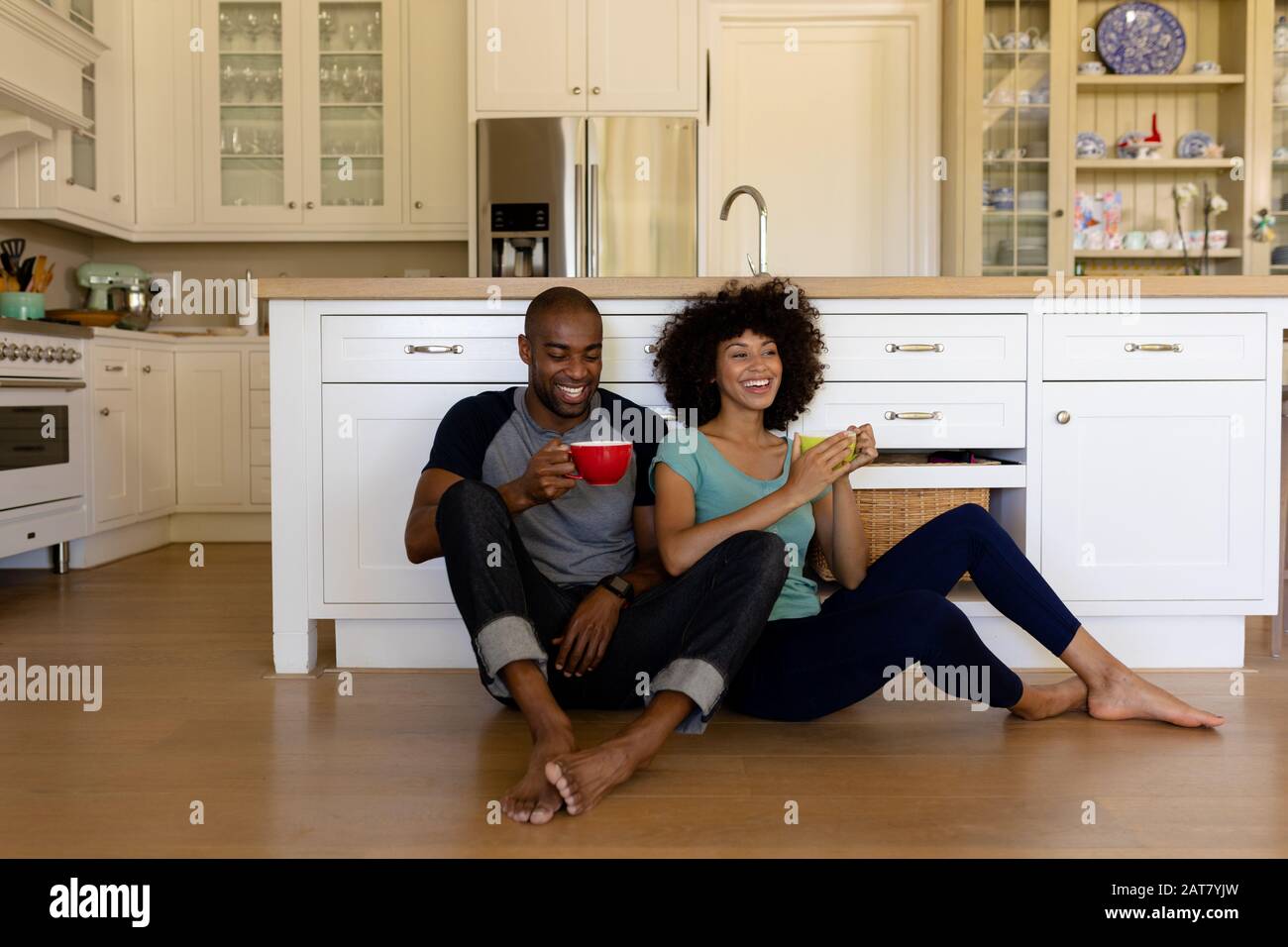 Happy young couple sitting in the kitchen Stock Photo