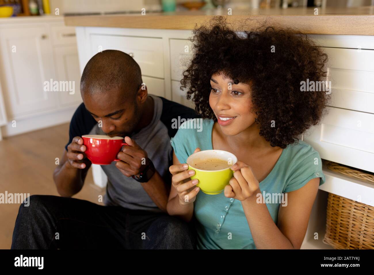Happy young couple sitting in the kitchen Stock Photo
