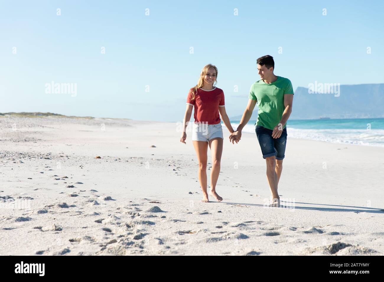 Young couple holding hands at the beach Stock Photo - Alamy