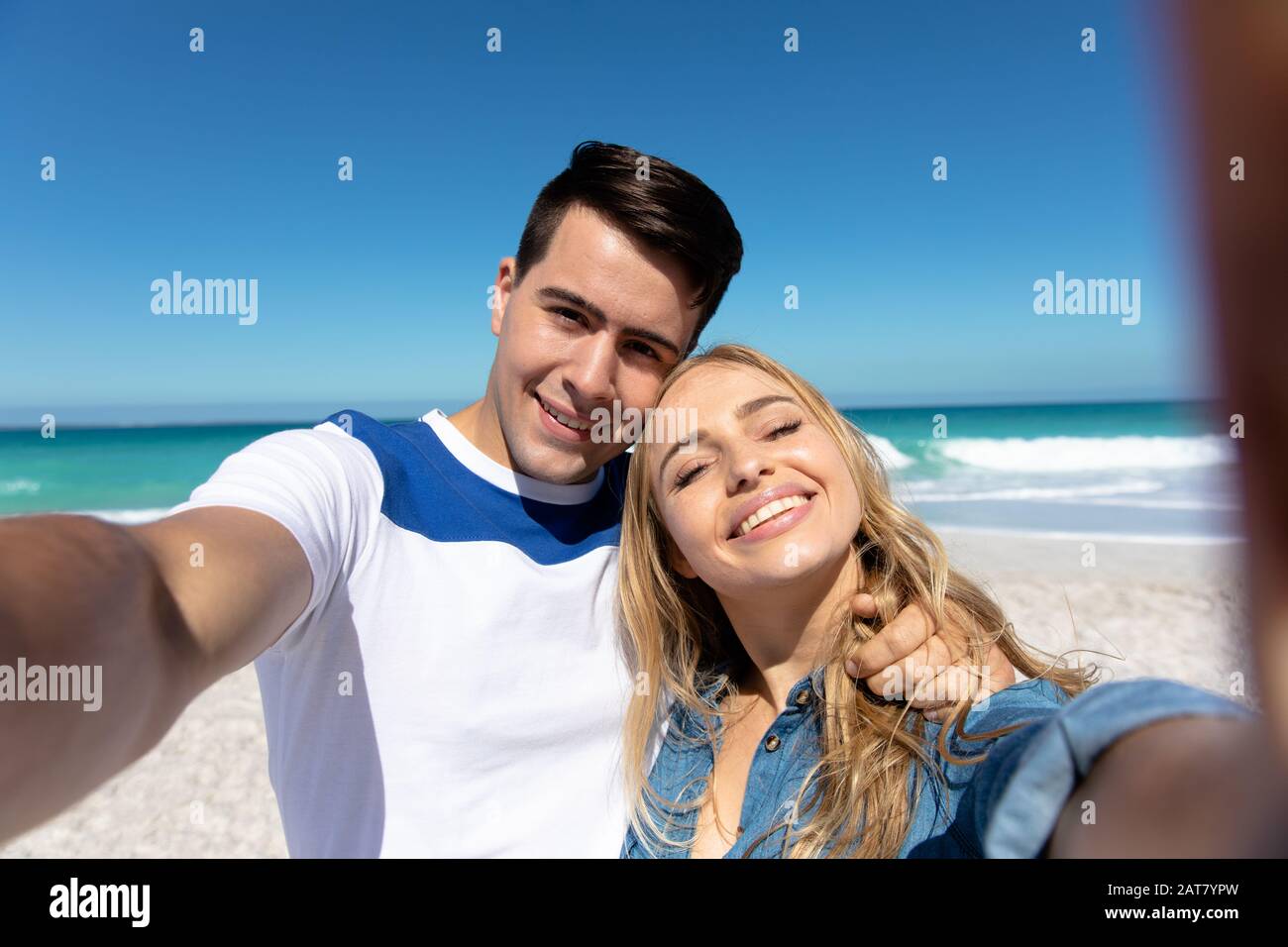 Young couple taking selfies at the beach Stock Photo