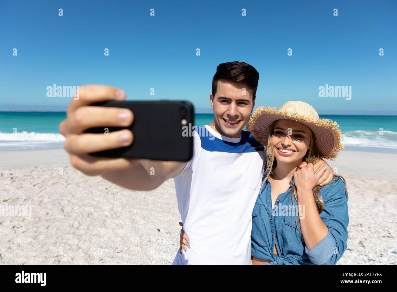 Young couple taking selfies at the beach Stock Photo